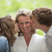 mother son daughter: son and daughter kissing mother on cheek