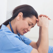 custody during coronavirus: Sad woman doctor leaning against a wall