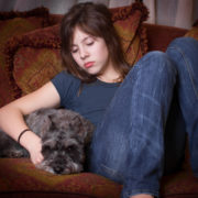 your teen cope with divorce: sad teen girl on couch with dog