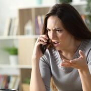 Woman talking to angry ex on the phone who needs to establish boundaries in their co-parenting communication