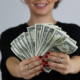 woman holding dollar bills fanned out in her hands